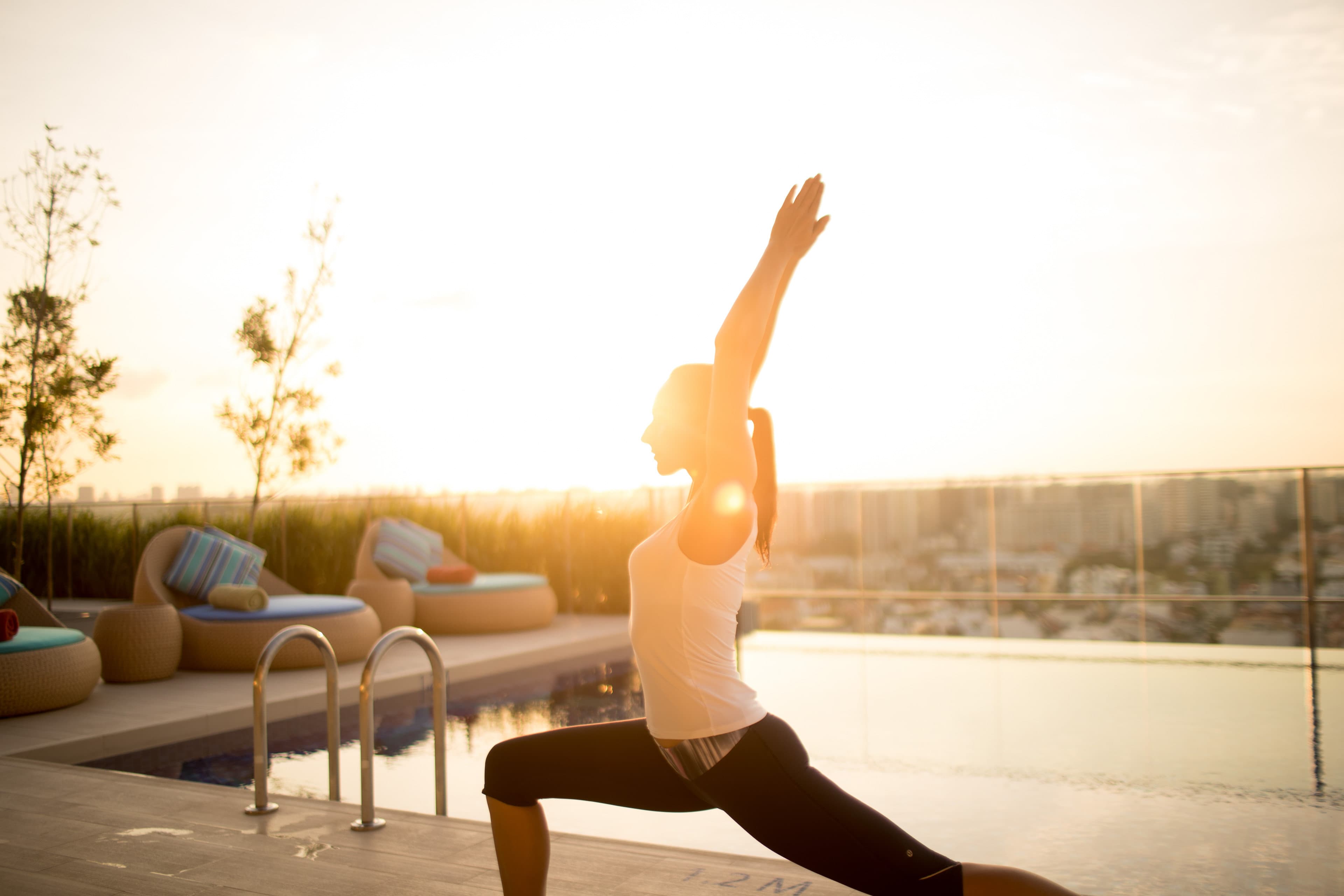 Enjoy a good stretch by the pool as the sun sets